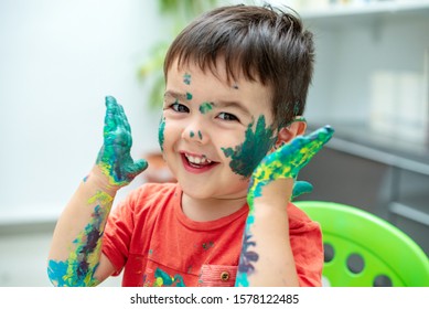 little boy playing with green paint