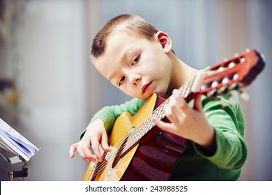 Little boy is playing the guitar at home - Powered by Shutterstock