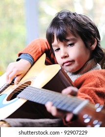 Little Boy Playing Guitar At Home