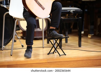 A little boy playing guitar on stage. The foot of a young musician on a stand. The concept of children's music education - Powered by Shutterstock