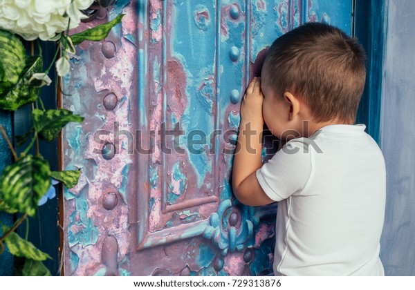 little boy playing hide and\
seek