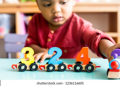 Little boy playing mathematics wooden toy at nursery