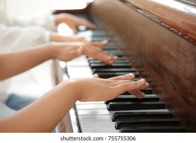 Little boy playing piano indoors