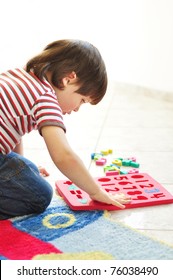 Little boy playing with puzzles on the floor