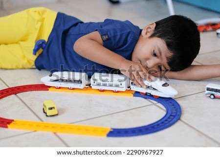 Little boy playing rail road toy. Kindergarten or preschool game.