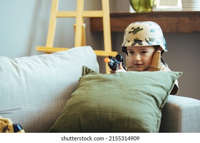 Little Boy Playing Soldiers In Living Room. In His Imagination The Boy Are Defending The Encircled City Of Bastogne Aganist The Enemy.  Entertainment For Kids Indoors. Offline Games.