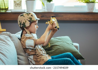 Little boy playing soldiers in living room. Little child is playing with toy. Knights and battles - favorite game for boys. Cute little toddler boy, playing at home with soldiers toys, playing wars