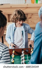 Little Boy Playing Table Football With His Family