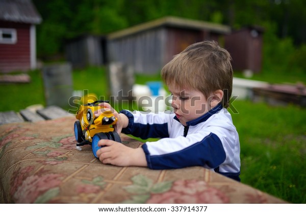 Little\
boy playing in toy bike in typical Russian\
village