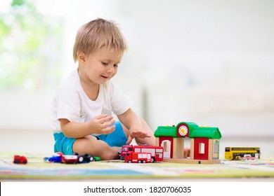 Little Boy Playing Toy Cars On Play Mat. Young Kid With Colorful Educational Vehicle And Transport Toys On Carpet. City Street Map Rug. Child Driving Car To Parking Garage. Kids At Home Or Daycare. 