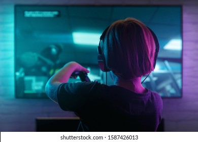Little boy playing video game in the dark room