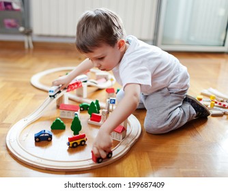 Little Boy Playing With Wooden Train Set