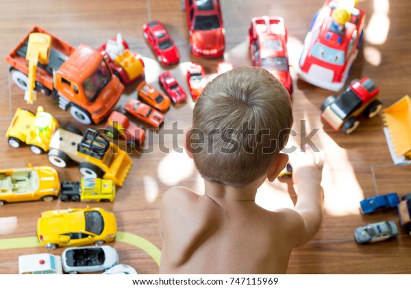 the little boy plays
cars