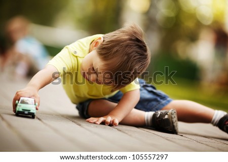 little boy plays with toy car