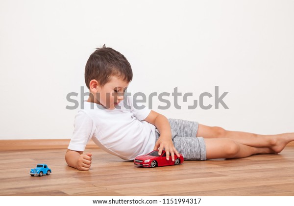 Little boy plays with toy\
car at home