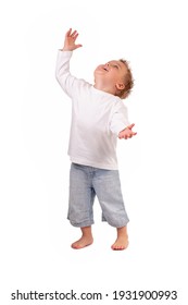 LITTLE BOY POINTING FINGER UP AND LOOKING HIGH WHILE STANDING BAREFOOT ISOLATED ON WHITE BACKGROUND