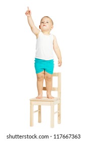 Little Boy Points Up Standing On Chair