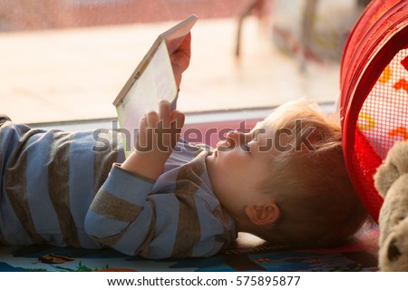 Little boy reading a book on the floor