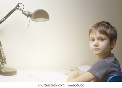 Little Boy Reading. Child Sitting At The Desk  Home.