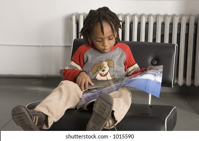 Little Boy Reading A Magazine