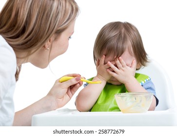 Little boy refuses to eat closing face by hands, isolated on white