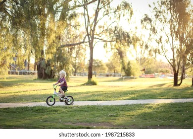 Little Boy Riding Bike Along Walking Track In Pretty Australian Bush Setting At Sunset