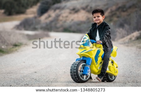 Little boy riding on motorcycle toy