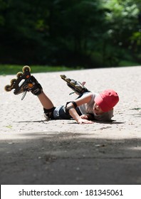 Little boy roller-skating falls by accident. He suffer and shows face of pain