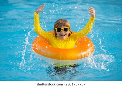 Little boy with rubber ring in swimming pool. Summertime fun. Little kid swimming in pool. Kid in swimming pool. Kid relax swim on inflatable ring. Summer vacation concept. - Powered by Shutterstock