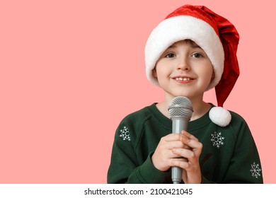 Little Boy In Santa Hat And With Microphone Singing Christmas Song On Color Background