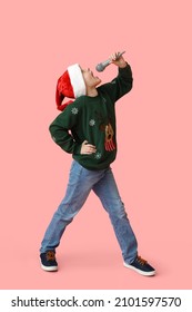 Little Boy In Santa Hat And With Microphone Singing Christmas Song On Color Background