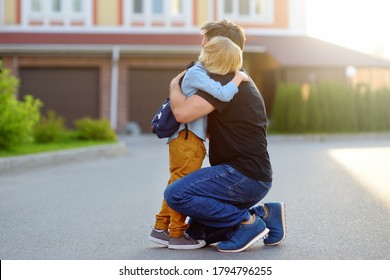 Little Boy Says Goodbye And Hugging To His Father Before Going To School. Education For Children. First Day Of School. Child's Fear.