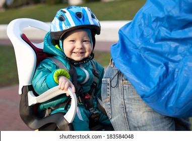 Little boy in the seat bicycle behind father
