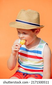 Little Boy Sit In Orange Sunbed And Eats Ice-cream