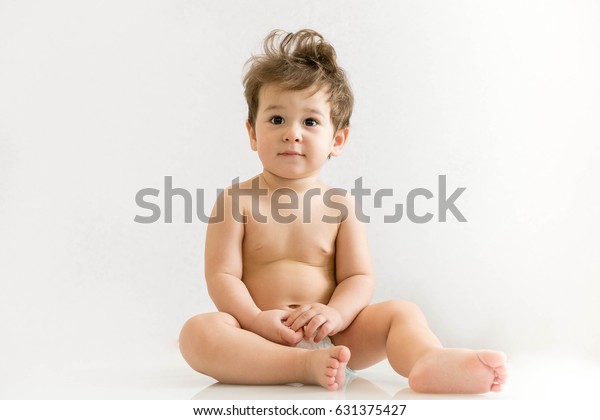 The little boy sits on the floor on white backgro