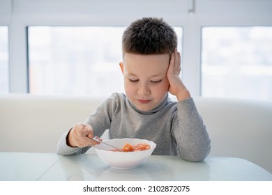 Little Boy Sits At The Table And Does Not Want To Eat Soup