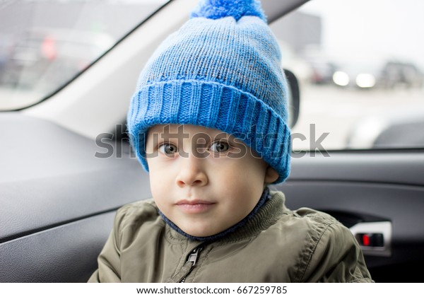 Little boy sitting
in the car in rainy
day..