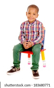 Little Boy Sitting In Chair Isolated In White