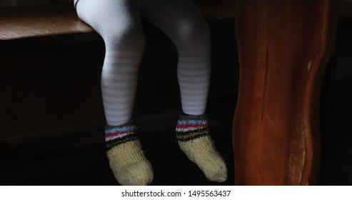 Little Boy Sitting At The Kitchen Table. Child Legs Under Table.  Breakfast.