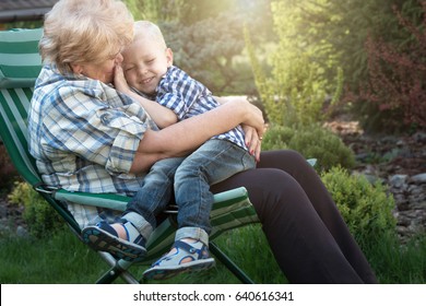 Little boy sitting on the arms of his beloved grandmother.Kisses and gentle hugs.Weekend in a country house. - Powered by Shutterstock