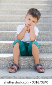 Little Boy Sitting On Stairs Outdoor. Outdoors Portrait Of Smart Child Boy 