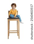 Little boy sitting on stool against white background