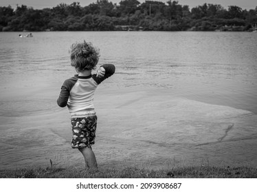 Little Boy Skipping Stones In A Lake