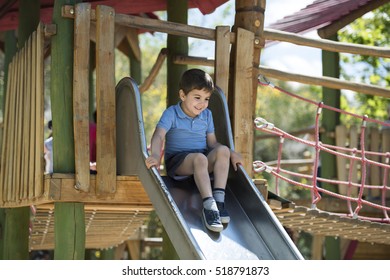 Little boy sliding down a slide at the playground