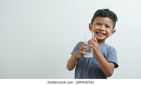 Little Boy Smiling and Holding a Glass Of Water - Powered by Shutterstock