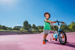 Little Boy Stand With His Bicycle At City Roller Park Wearing Helmet And Learning To Ride