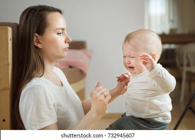 Little Boy Started Crying, Serious Worried Mother Looking At Him. Baby Toddler Feels Bad, Concerned Mom Wants To Help Her Kid