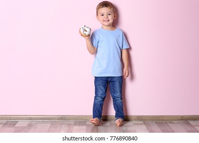 Little Boy With Sweet Donut Near Color Wall