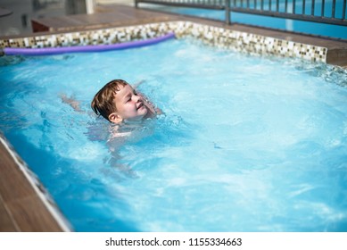 Little boy swiming in pool in summer holidays 