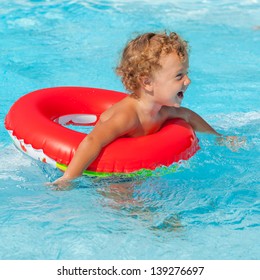 Little Boy In The Swimming Pool  With Rubber Ring